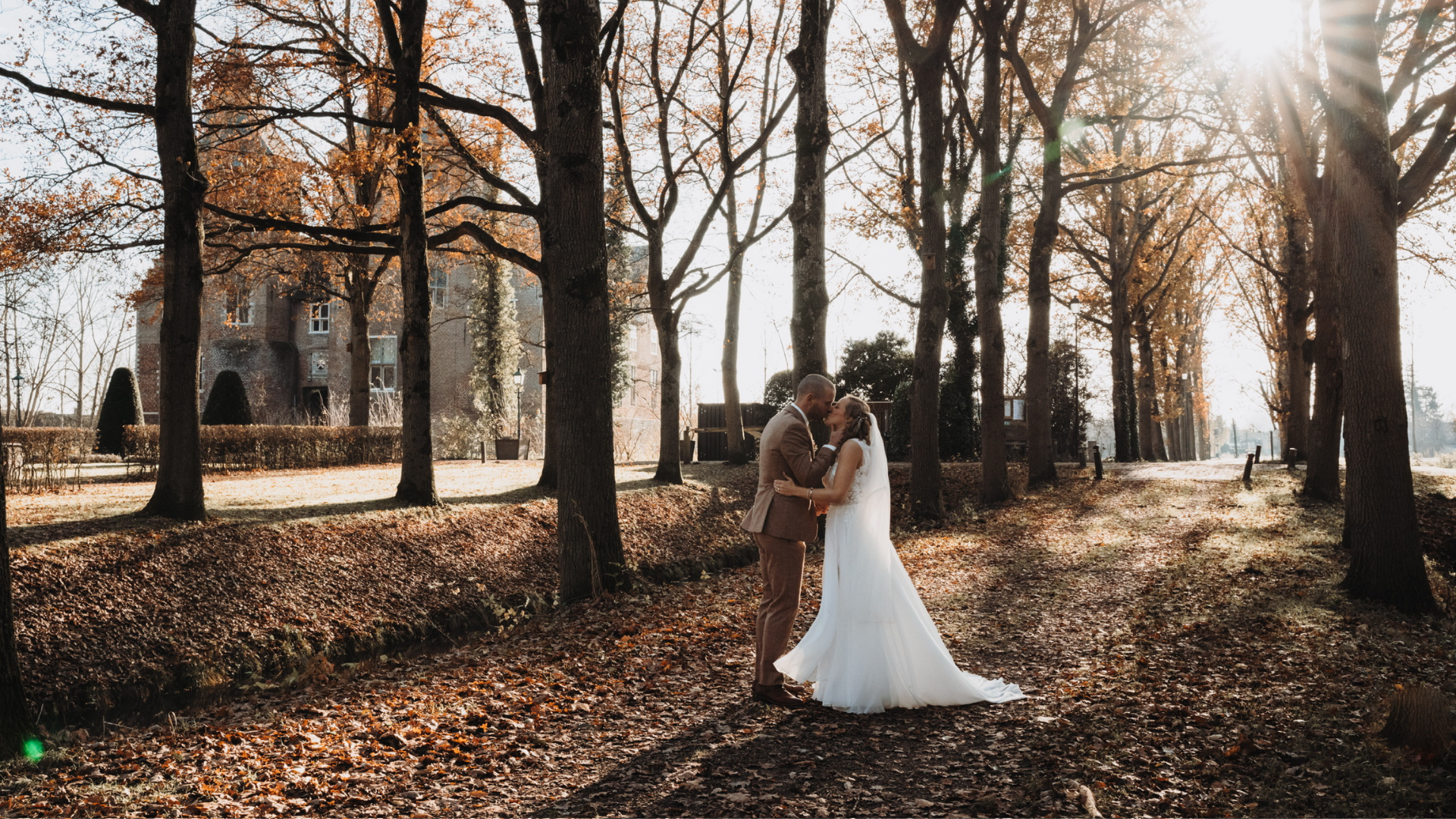 man en vrouw kussen tussen de bomen